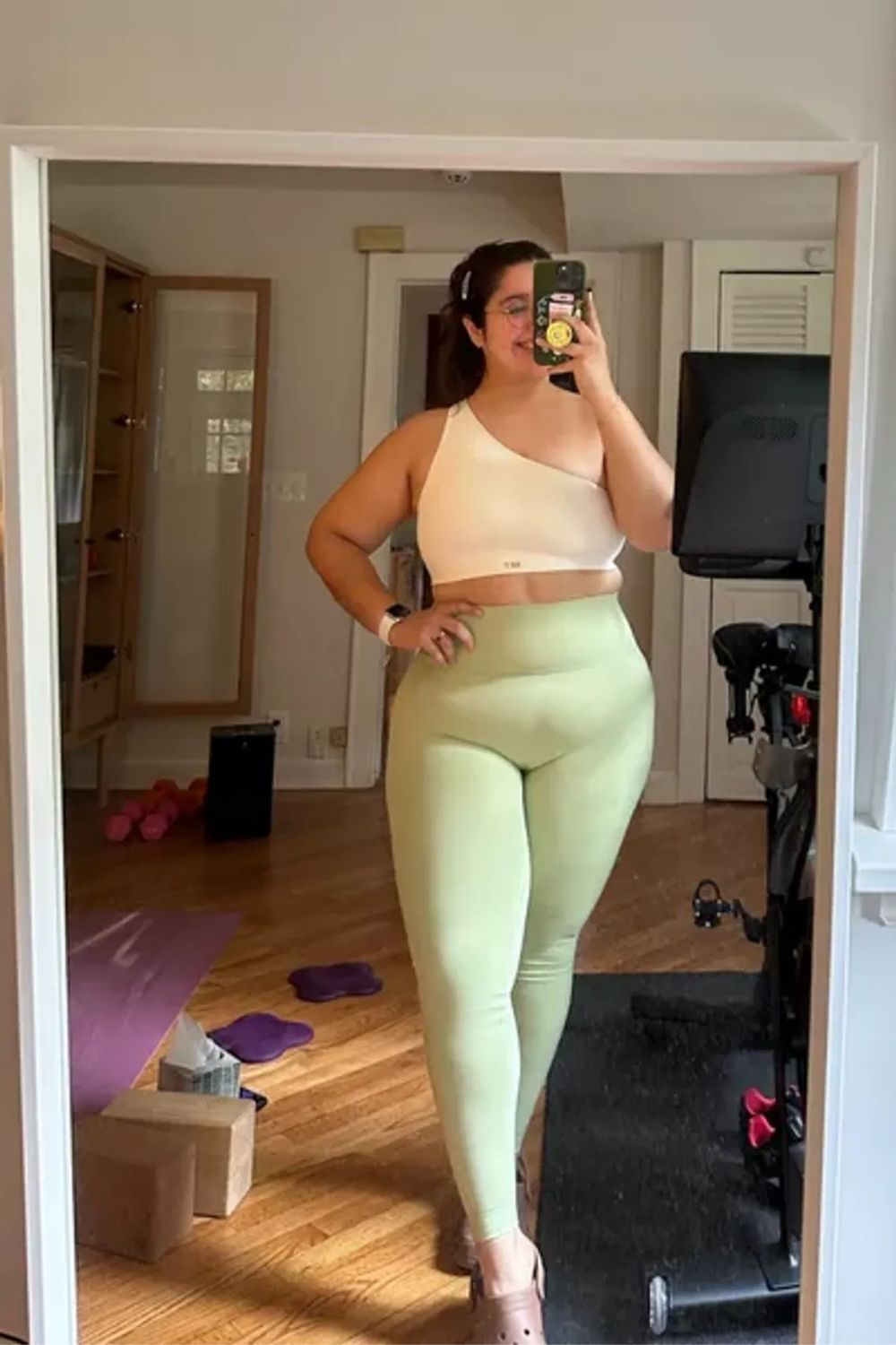 Pastel green high-waisted leggings and a neutral cropped top.