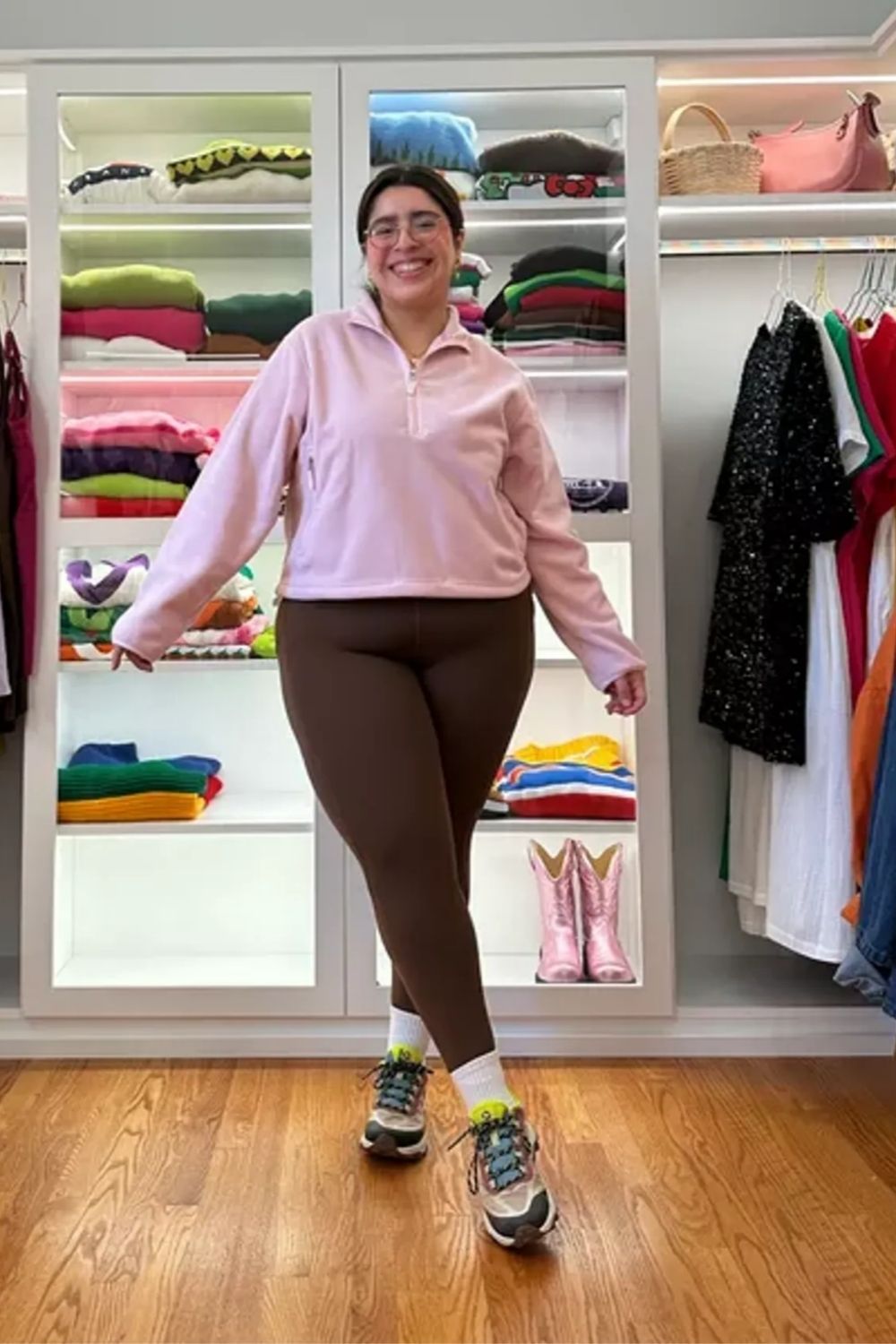 Stylish combination of a pastel pink sweatshirt, fitted leggings, and patterned sneakers.