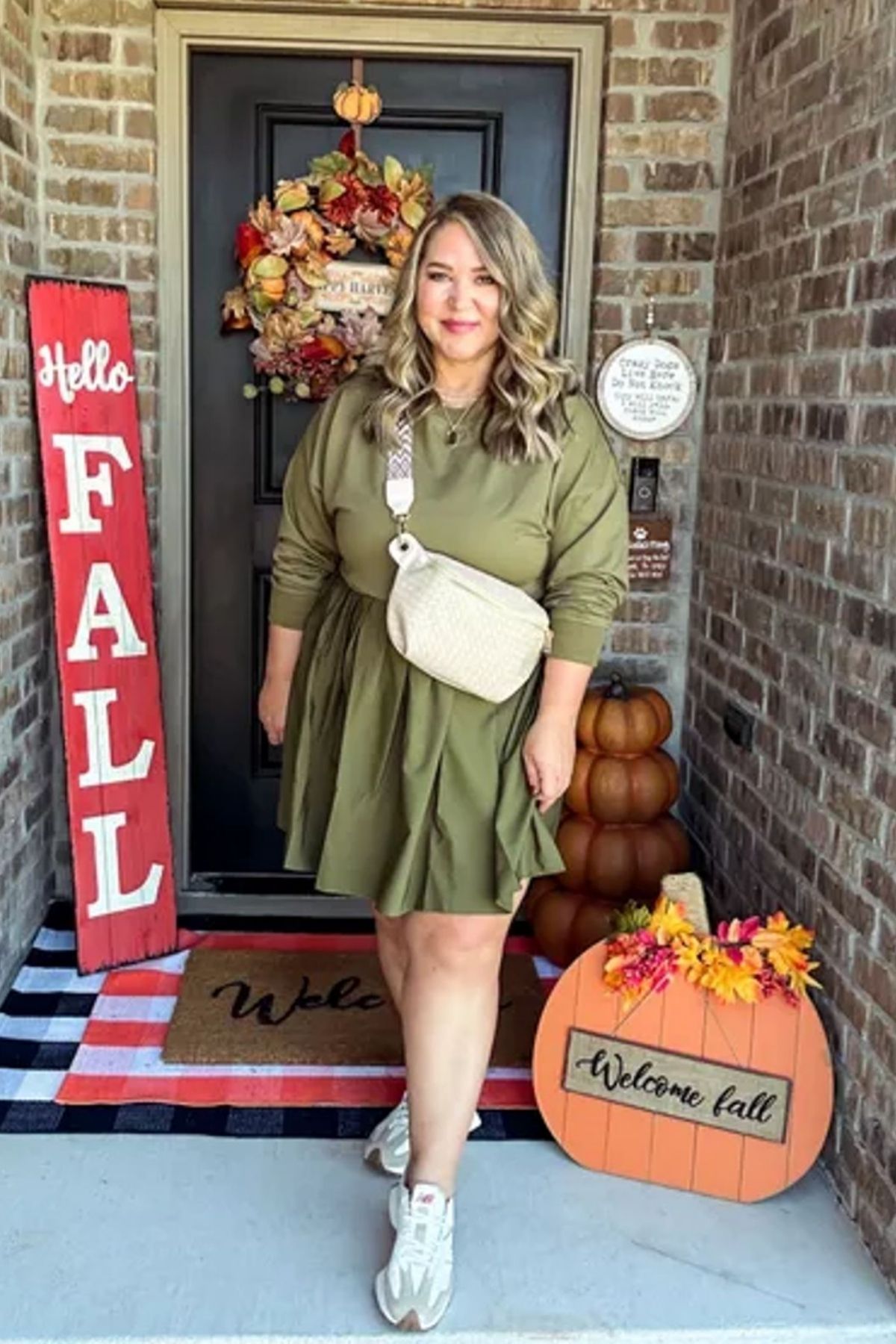 Olive green dress, cinched waist, white crossbody bag, white sneakers.