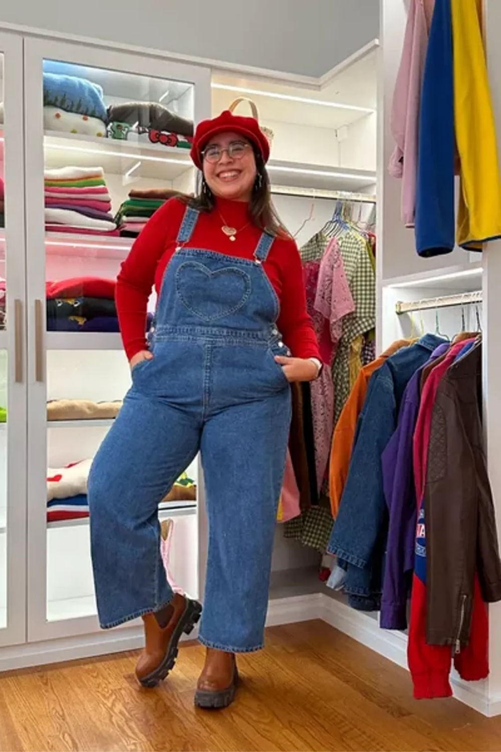Presenting a playful yet chic take on classic denim overalls, this outfit pairs them with a bright red long-sleeve top, creating a striking color contrast that's eye-catching and trendy. The addition of a red beret and stylish eyeglasses adds a touch of Parisian flair, making the ensemble fashion-forward and cohesive.